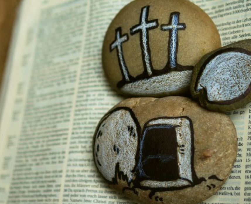 Bijbel met stenen waarop paasafbeeldingen staan